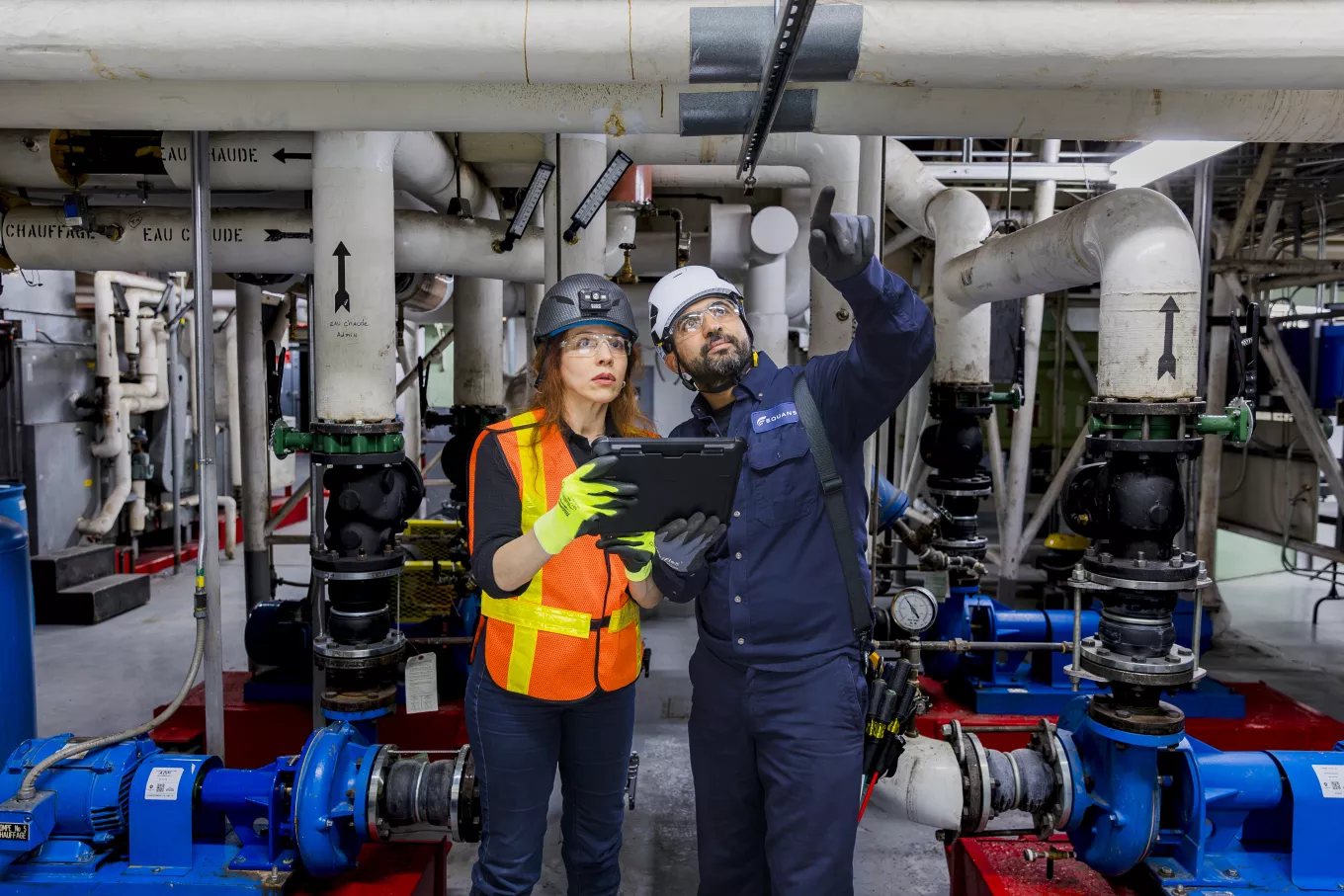  ouvriers du bâtiment utilisant une tablette pour vérifier la tuyauterie